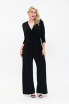 Female model in black wrap jumpsuit. Front view