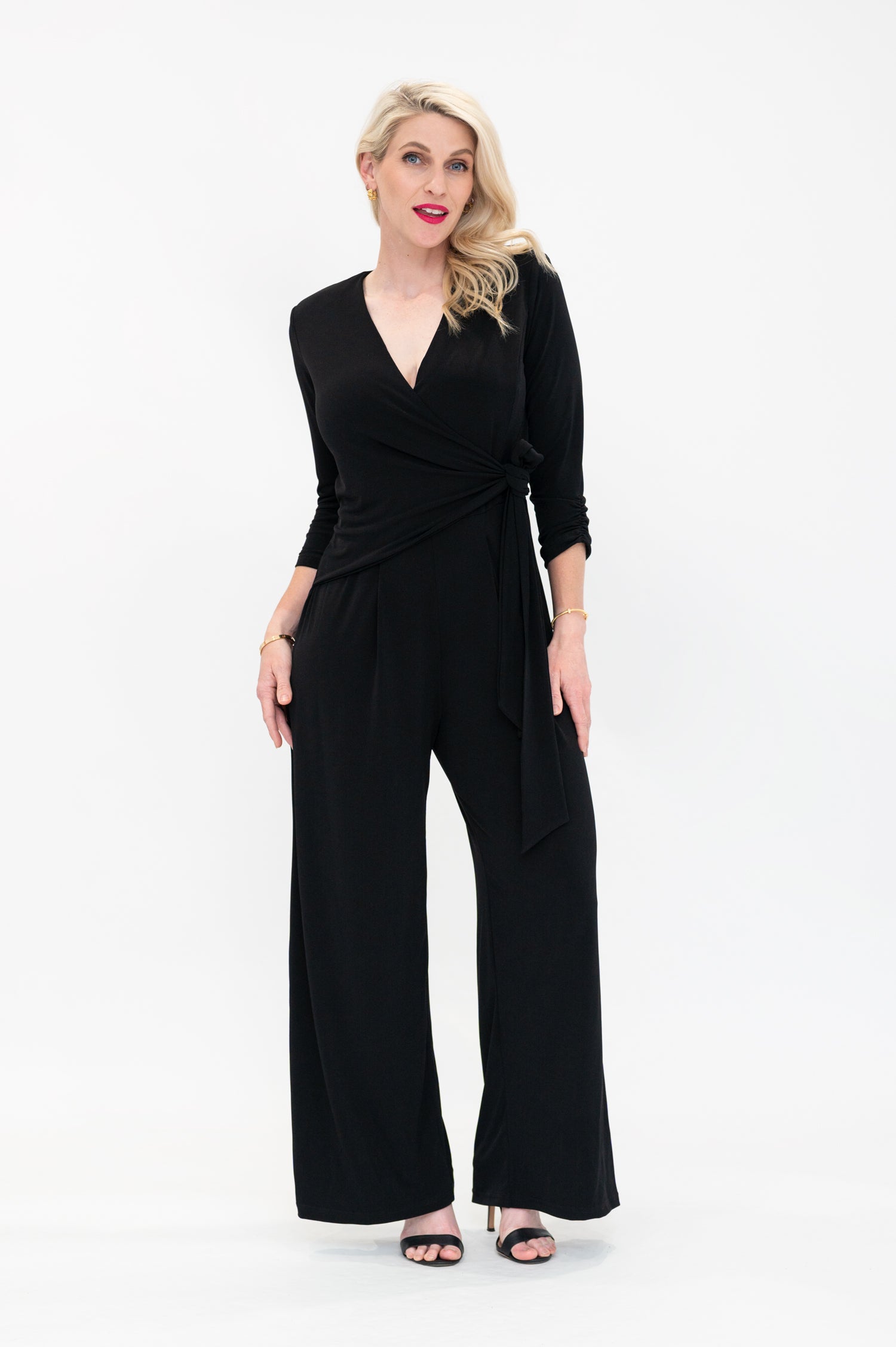 Female model in black wrap jumpsuit. Front view