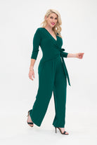 Female model in green wrap jumpsuit. Side view