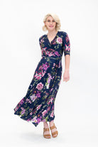 Model wearing the Hazel floral wrap dress by By Samantha Melbourne. Curve-friendly fit with a deep navy base and pink botanical print.