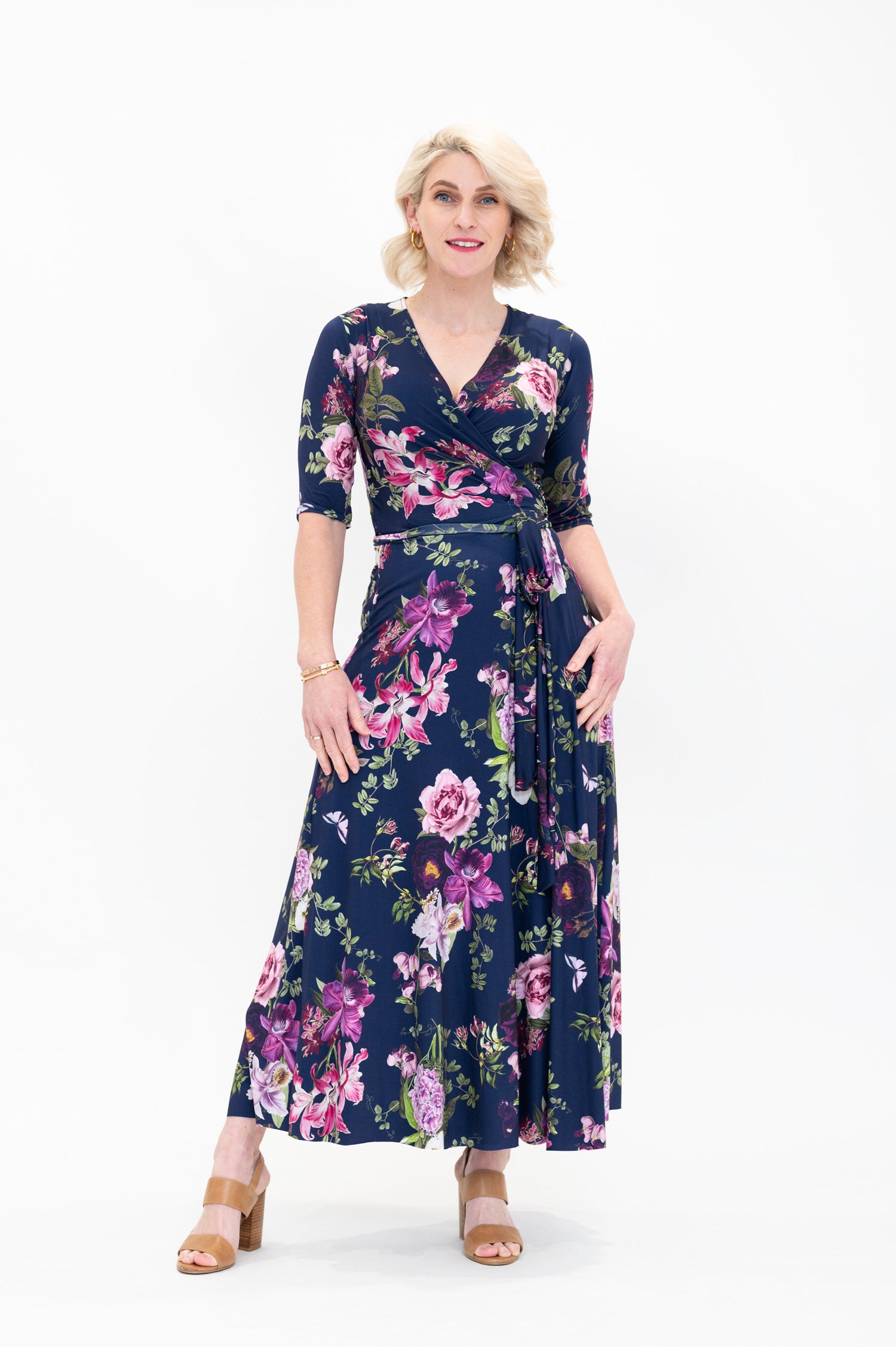 Model wearing the Hazel floral wrap dress by By Samantha Melbourne. Curve-friendly fit with a deep navy base and pink botanical print.