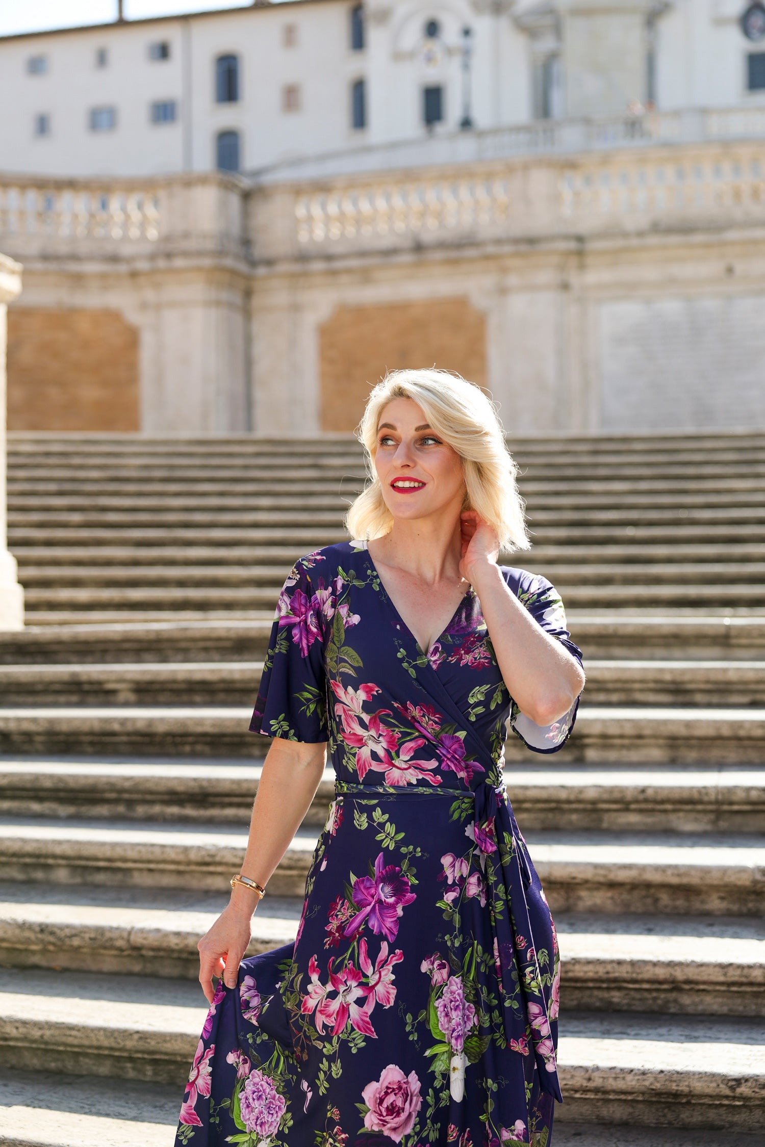 Model wearing the Hazel floral wrap dress by By Samantha Melbourne. Curve-friendly fit with a deep navy base and pink botanical print.
