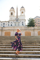 Model wearing the Hazel floral wrap dress by By Samantha Melbourne. Curve-friendly fit with a deep navy base and pink botanical print.