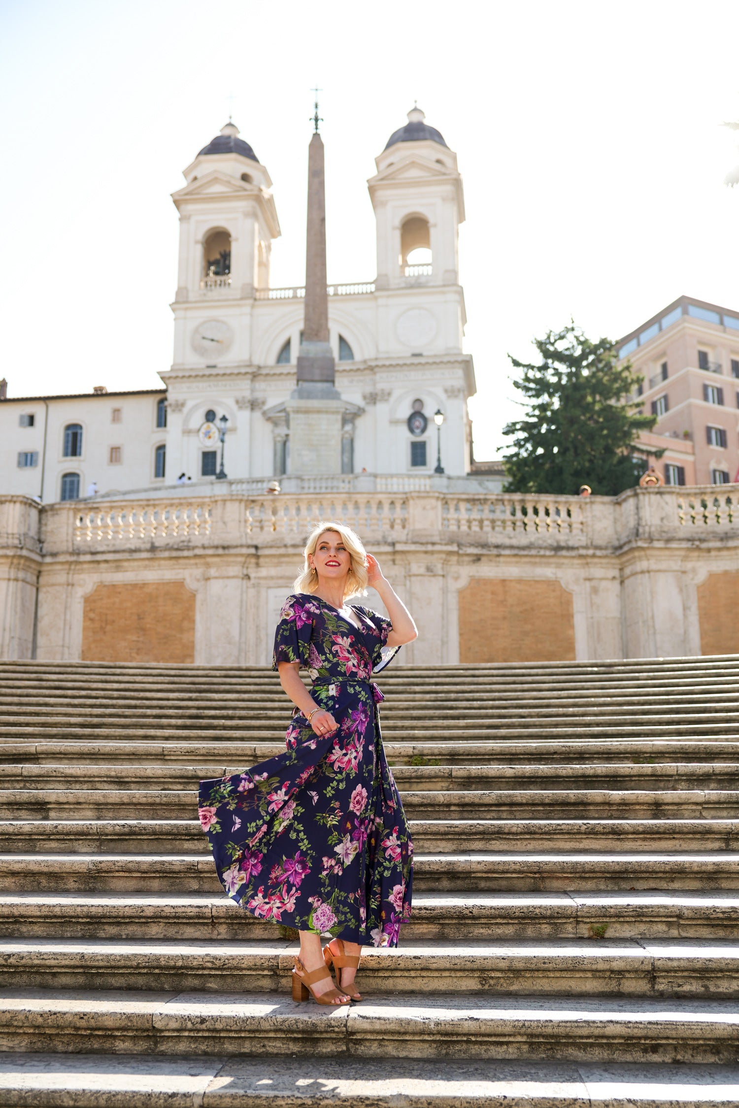 Model wearing the Hazel floral wrap dress by By Samantha Melbourne. Curve-friendly fit with a deep navy base and pink botanical print.