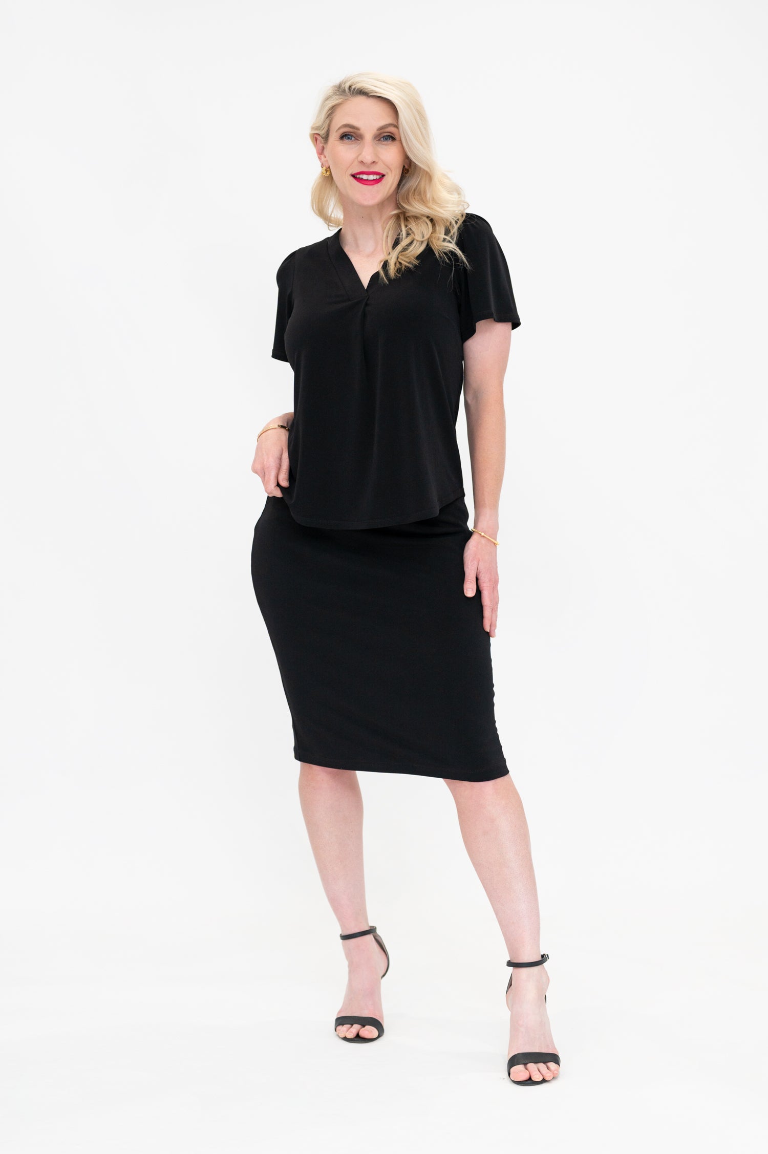 By Samantha Melbourne Officewear. Model wears Gina the V-neck blouse with flutter sleeve in black with Andy the pencil skirt in knee-length in black
