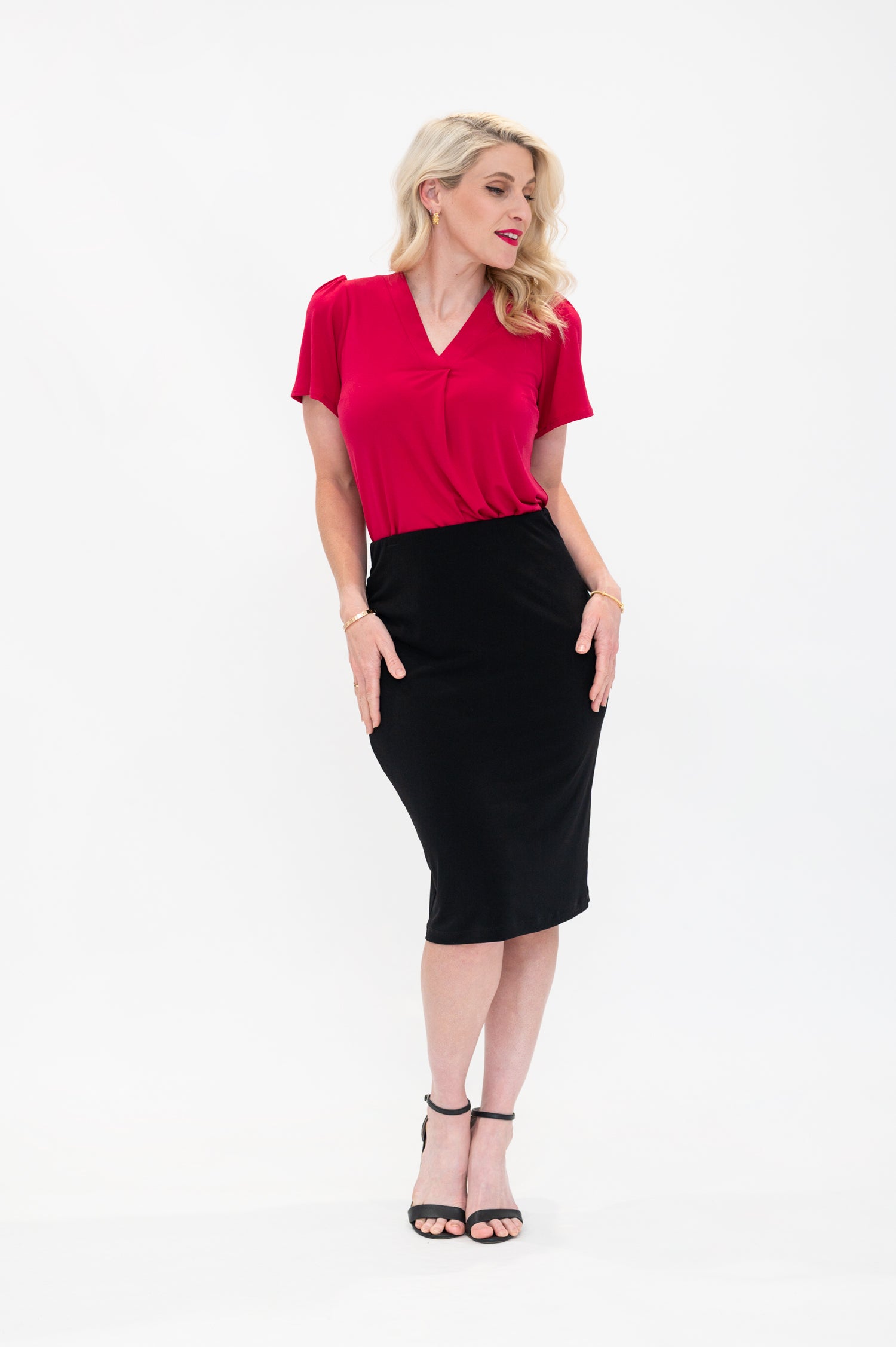 By Samantha Melbourne Officewear. Model wears Gina the V-neck blouse with flutter sleeve in granita raspberry red colour with Andy pencil skirt in knee-length in black.