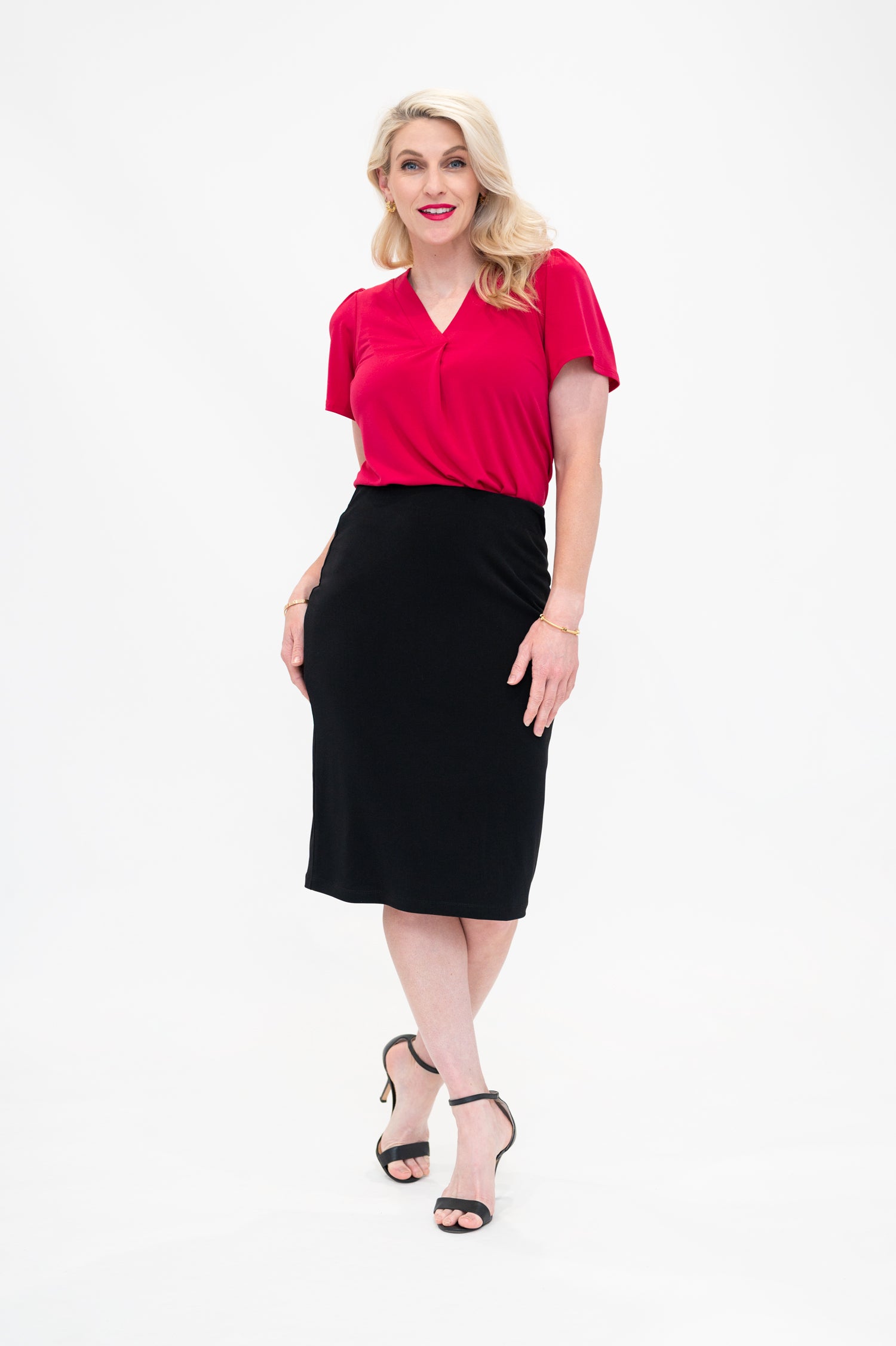 By Samantha Melbourne Officewear. Model wears Gina the V-neck blouse with flutter sleeve in granita raspberry red colour with Andy pencil skirt in knee-length in black.