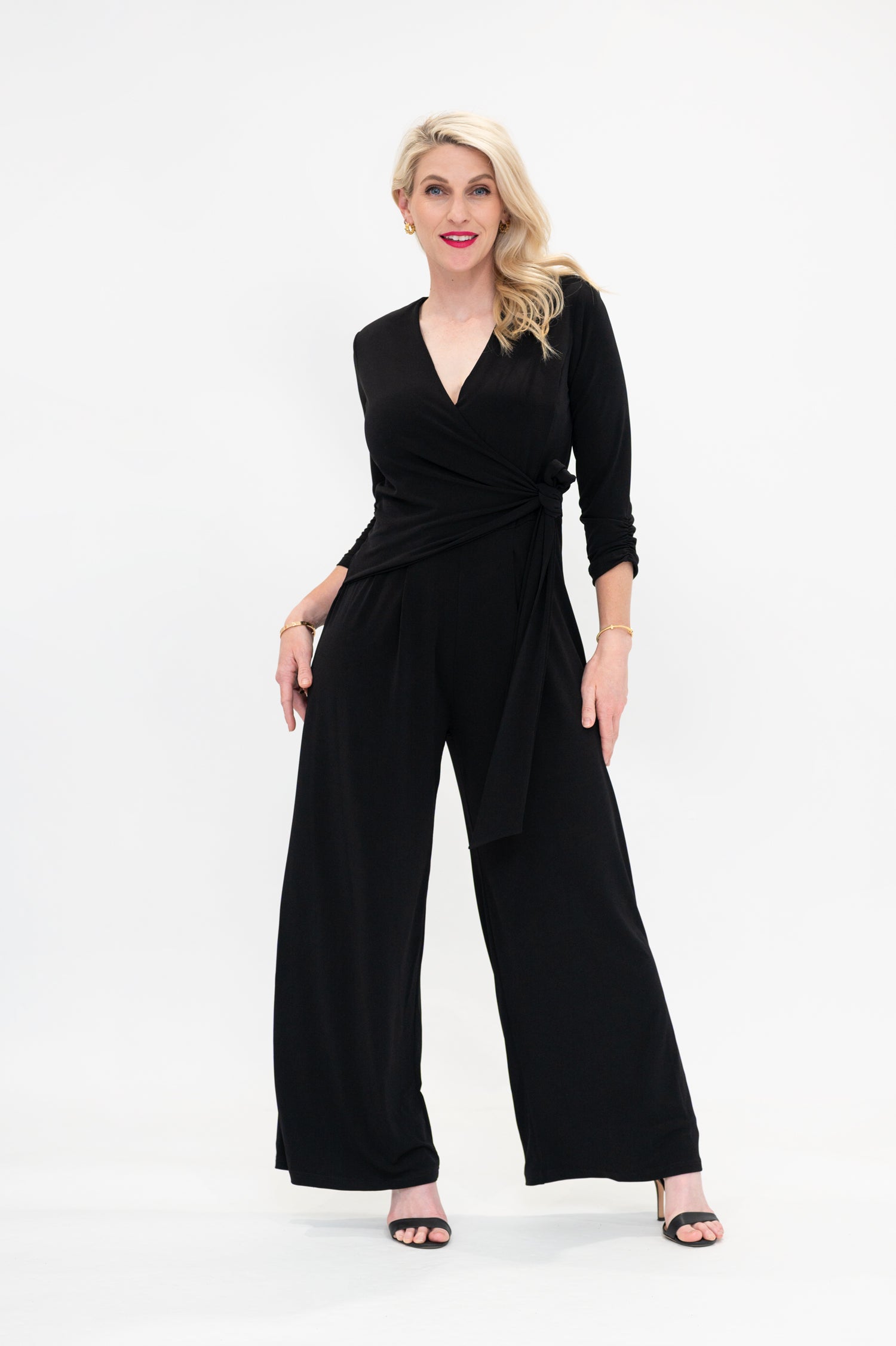 Female model in black wrap jumpsuit. Front view