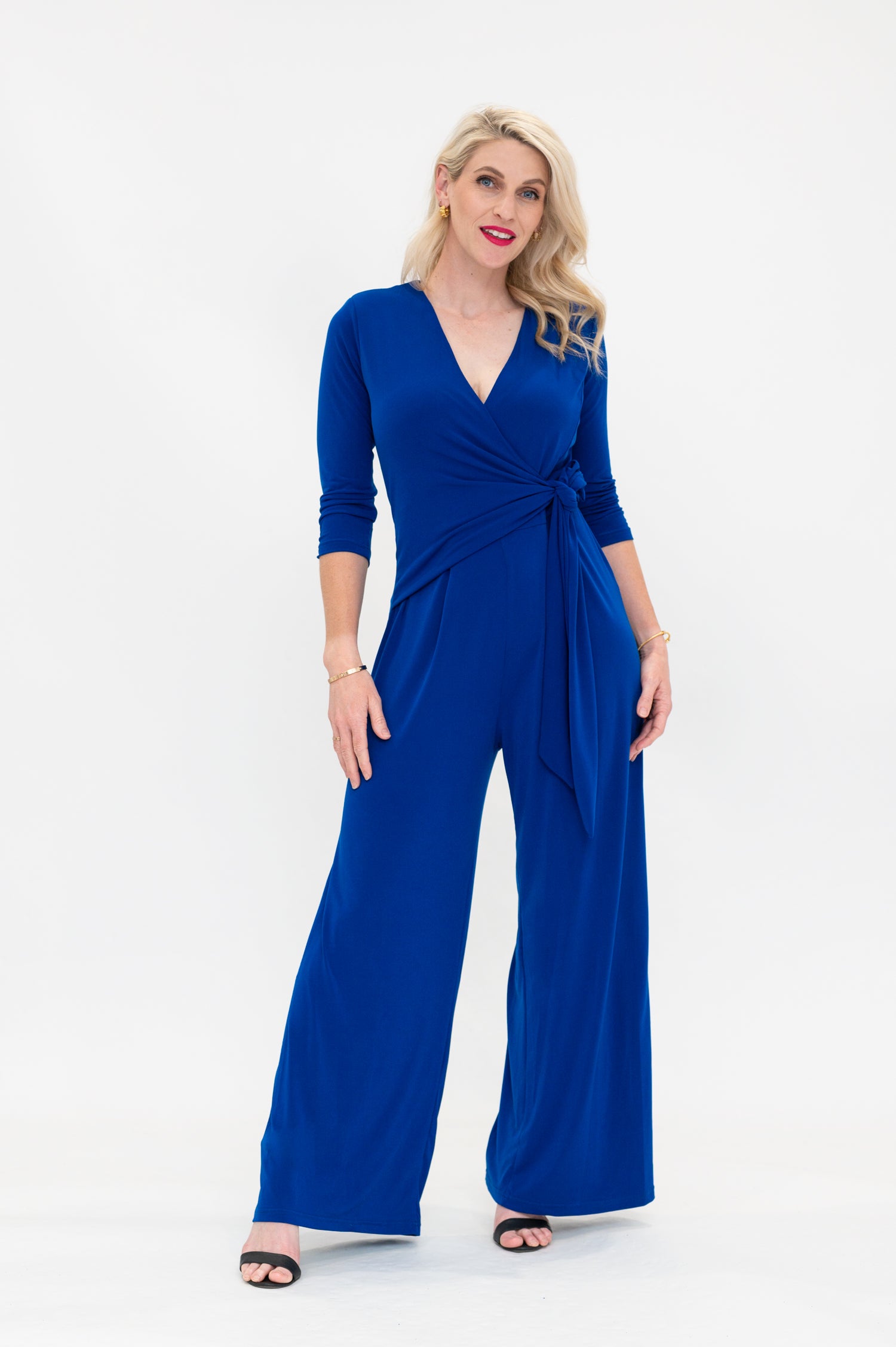 Female model in cobalt blue wrap jumpsuit. Front view