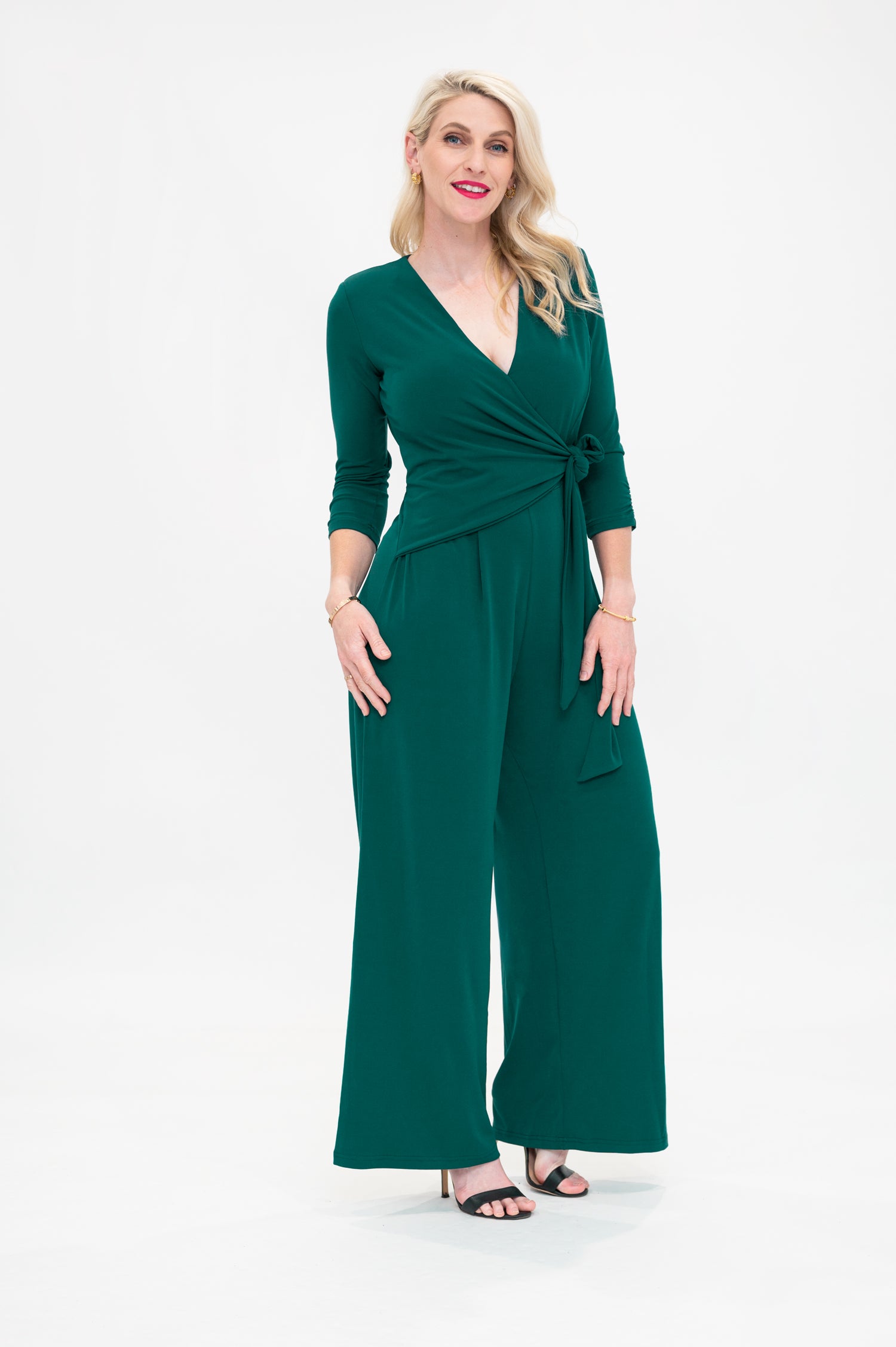 Female model in green wrap jumpsuit. Side view