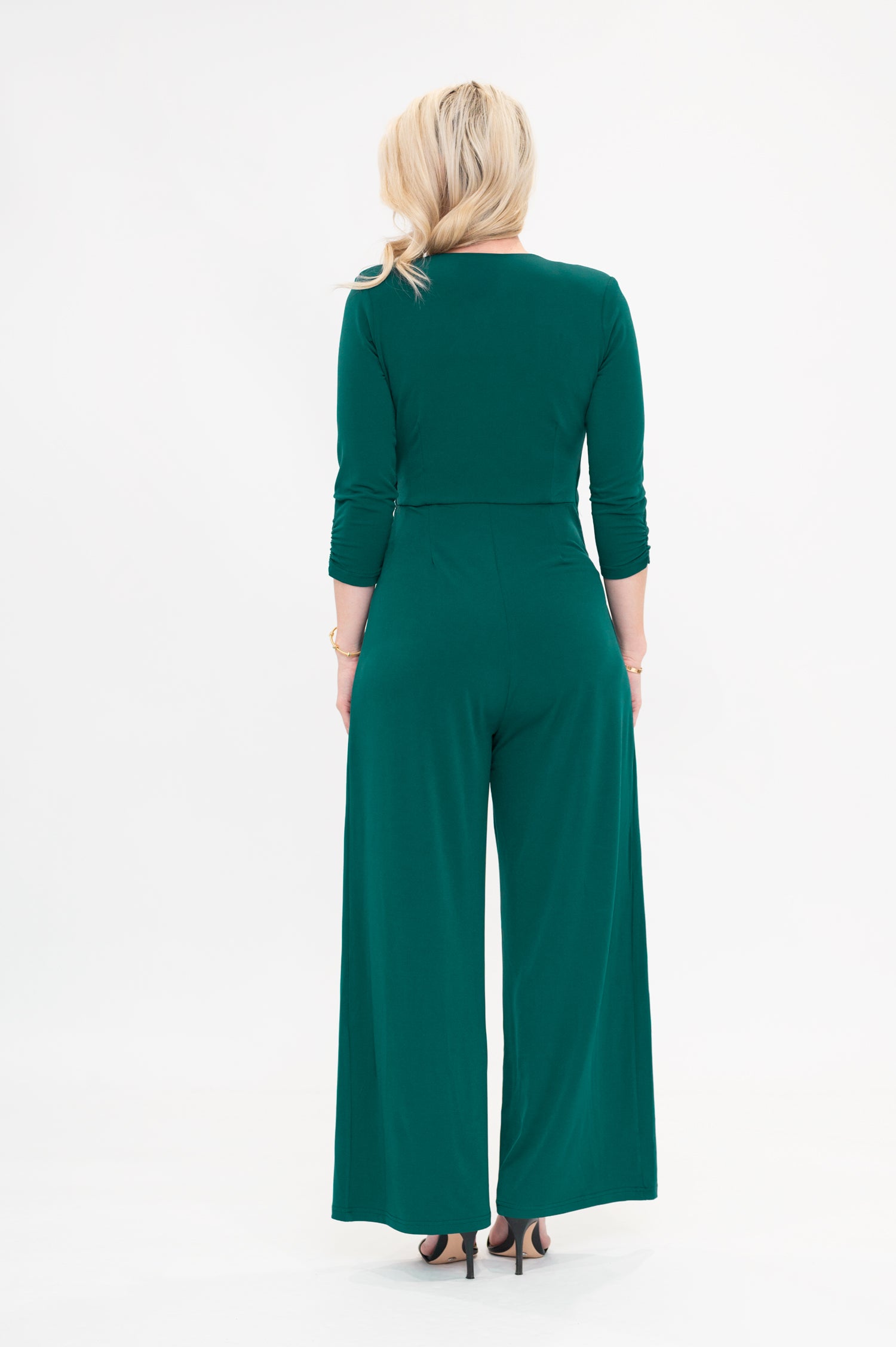 Female model in green wrap jumpsuit. Back view