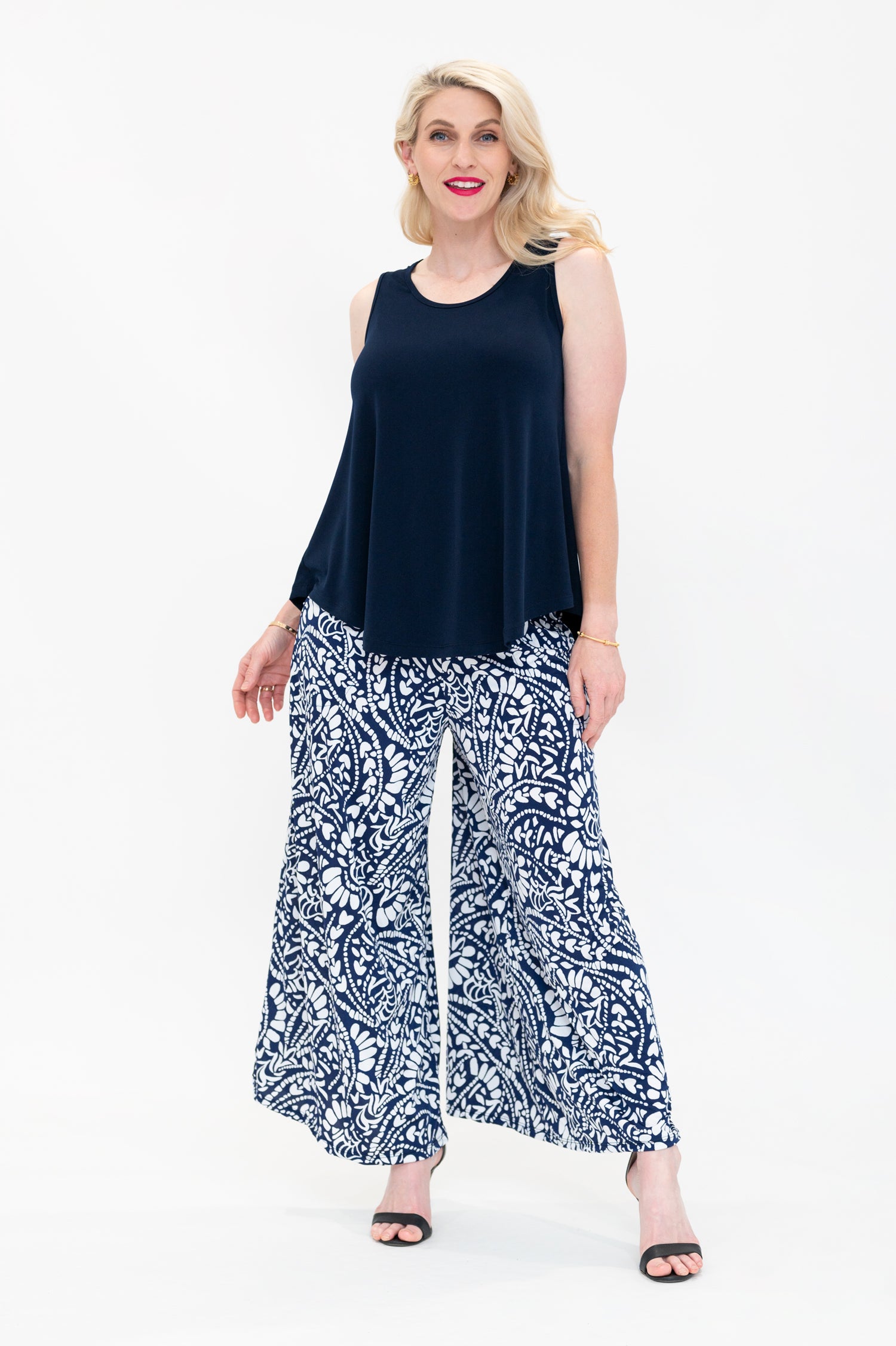 By Samantha Melbourne Erin Swing Singlet. Available in 3 colours. Made in Australia. Model wears Erin Singlet in Navy. Erin Singlet is sleeveless, features Round Crew Neck, Swing style and Relaxed fit, Hip length. Singlet is untucked into By Samantha Melbourne Palazzo Pants