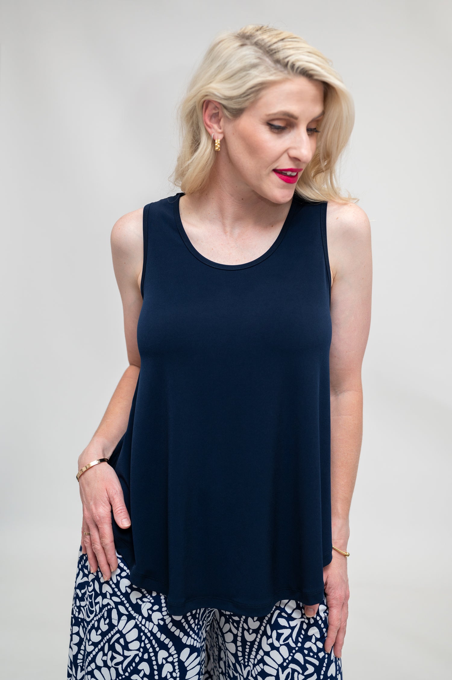 By Samantha Melbourne Erin Swing Singlet. Available in 3 colours. Made in Australia. Model wears Erin Singlet in Navy. Erin Singlet is sleeveless, features Round Crew Neck, Swing style and Relaxed fit, Hip length. Singlet is tucked ino By Samantha Melbourne Palazzo Pants. Closeup