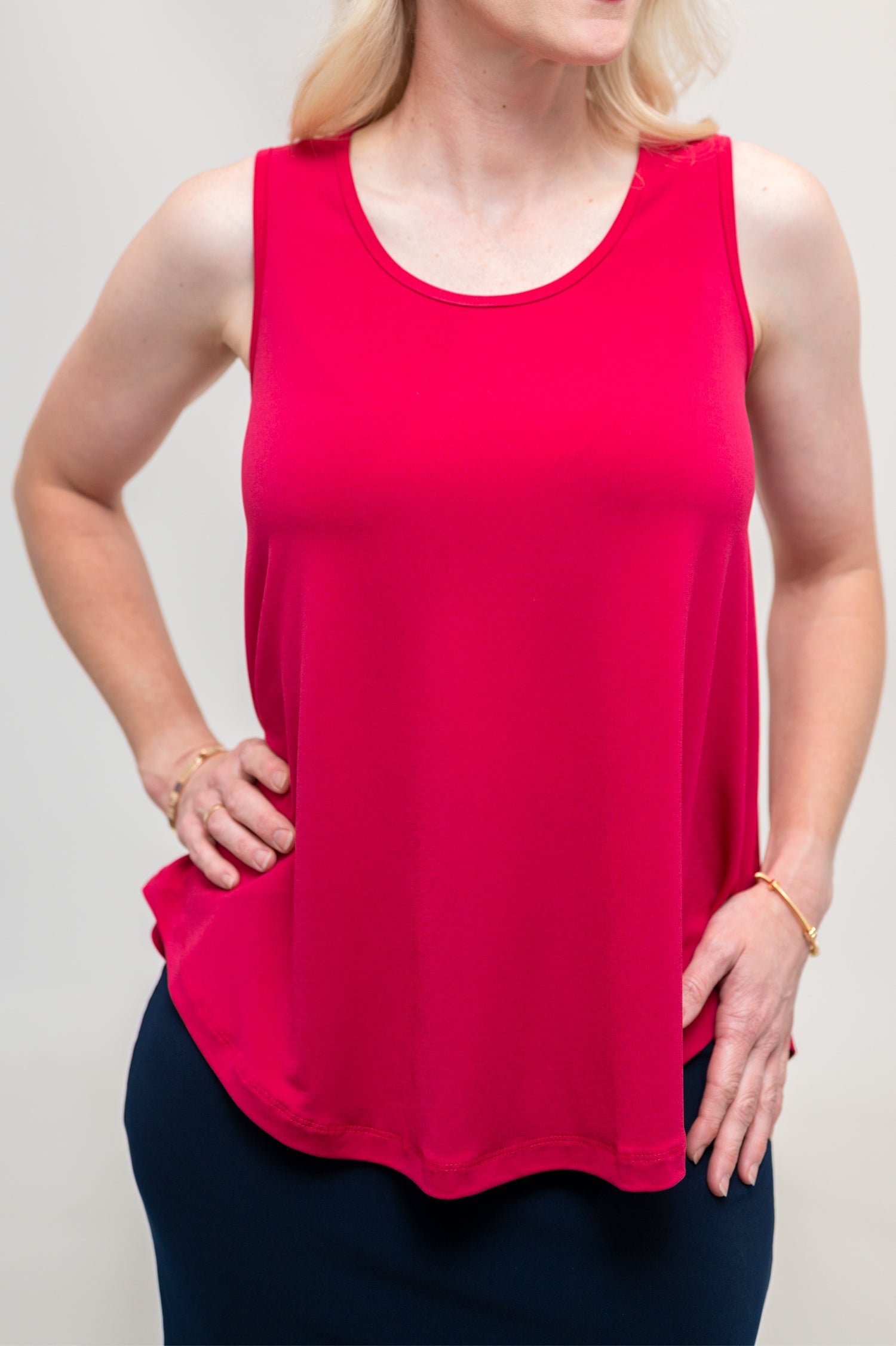 By Samantha Melbourne Erin Swing Singlet. Available in 3 colours. Made in Australia. Model wears Erin Singlet in Red. Erin Singlet is sleeveless, features Round Crew Neck, Swing style and Relaxed fit, Hip length. Singlet is untucked and paired with By Samantha Melbourne Andy Pencil Skirt in Navy. Closeup