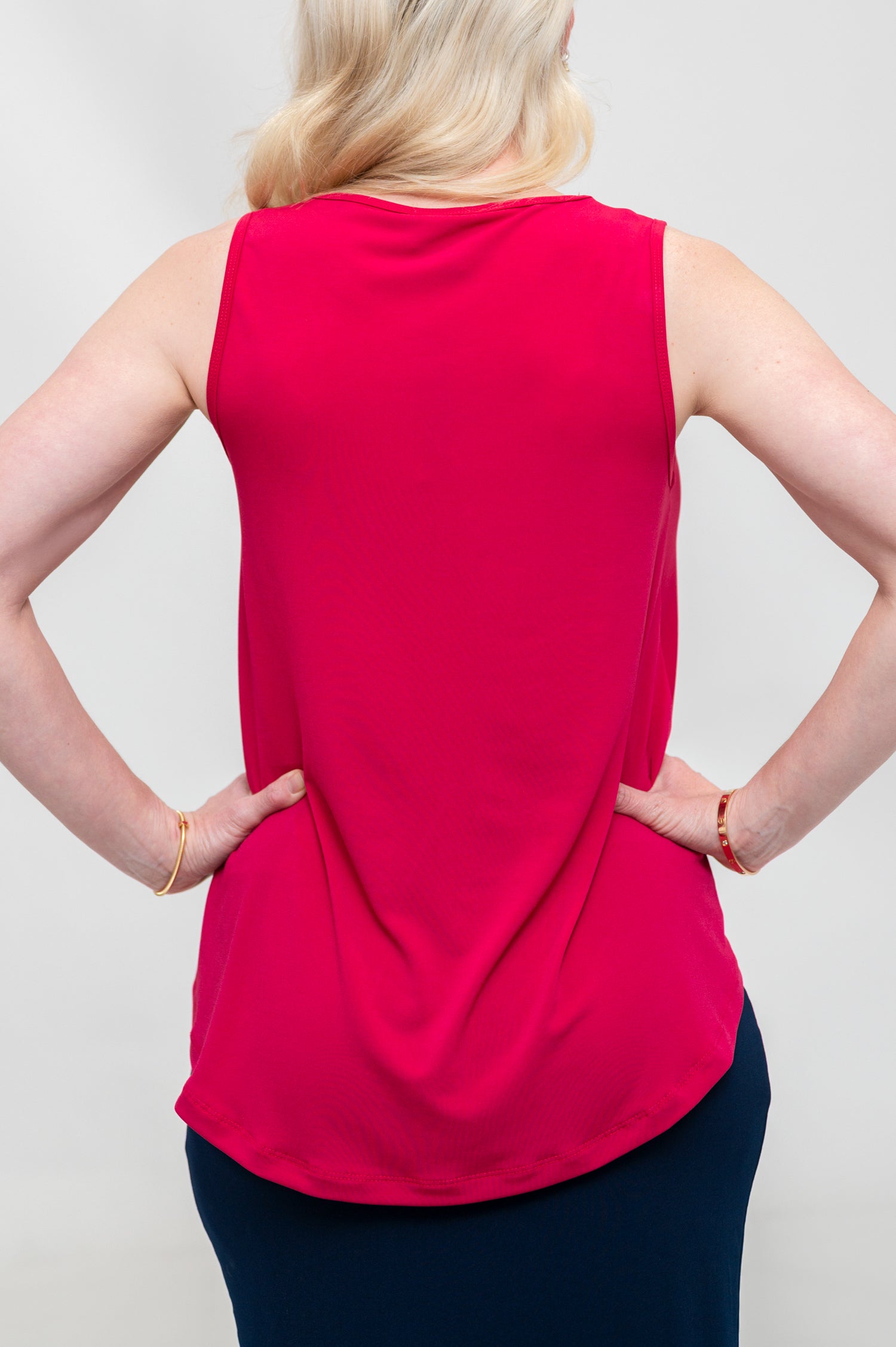 By Samantha Melbourne Erin Swing Singlet. Available in 3 colours. Made in Australia. Model wears Erin Singlet in Red. Erin Singlet is sleeveless, features Round Crew Neck, Swing style and Relaxed fit, Hip length. Singlet is untucked and paired with By Samantha Melbourne Andy Pencil Skirt in Navy. Closeup of the back