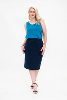 By Samantha Melbourne Erin Swing Singlet. Available in 3 colours. Made in Australia. Model wears Erin Singlet in Blue. Erin Singlet is sleeveless, features Round Crew Neck, Swing style and Relaxed fit, Hip length. Singlet is tucked and paired with By Samantha Melbourne Andy Pencil Skirt in Navy