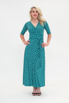 The female model wears a wrap dress in midi length (ankle length) with 3/4 sleeves. The print is a small-scale deep navy, white and teal geometric diamond shape pattern. Front view