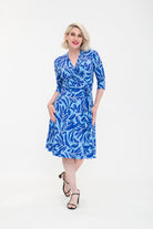 Woman wearing a blue patterned dress on a white background