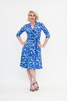 Woman wearing a blue patterned dress on a white background