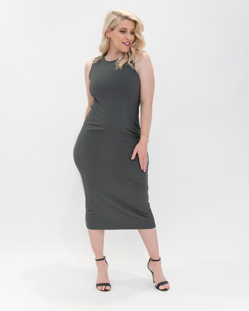 green midi length body con dress looking to the side